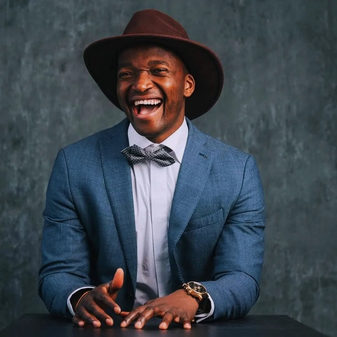 Isaac Bullock — laughing in suit and hat